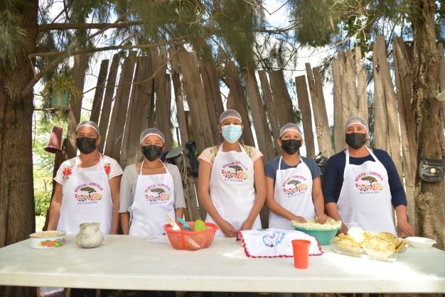 Grupo de mujeres exponiendo su receta balanceada con alimentos que ellas mismas producen.